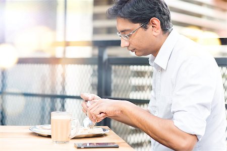 Asian Indian businessman eating roti at cafeteria. Photographie de stock - Aubaine LD & Abonnement, Code: 400-08111386