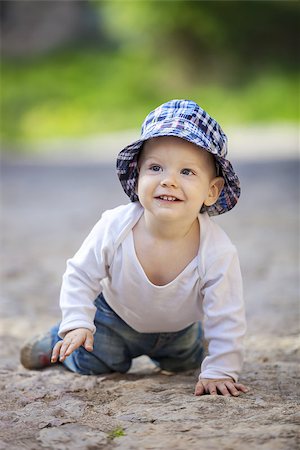 Cute little boy looking up and smiling while crawling on stone paved sidewalk Stock Photo - Budget Royalty-Free & Subscription, Code: 400-08111728