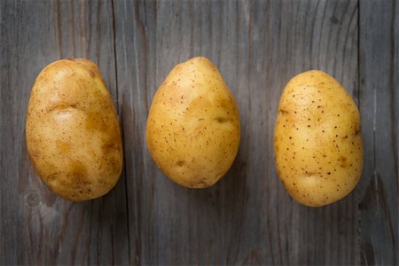 simsearch:400-09112314,k - Fresh Potato on Wooden Table Background, Concept and Idea of Food Cook Rustic Still life Style. Dramatic light table setting. Fotografie stock - Microstock e Abbonamento, Codice: 400-08112246