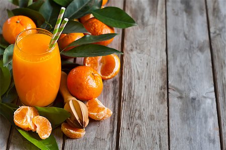 simsearch:400-05046087,k - Glass of fresh tangerine juice with ripe tangerines, leaves and old-fashioned straws. Copy space background. Stockbilder - Microstock & Abonnement, Bildnummer: 400-08112754