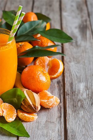 simsearch:400-07613620,k - Glass of fresh tangerine juice with ripe tangerines, leaves and old-fashioned straws. Copy space background. Stockbilder - Microstock & Abonnement, Bildnummer: 400-08112755