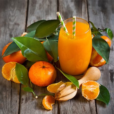 simsearch:400-07613620,k - Glass of fresh tangerine juice with ripe tangerines, leaves and old-fashioned straws. Stockbilder - Microstock & Abonnement, Bildnummer: 400-08112756