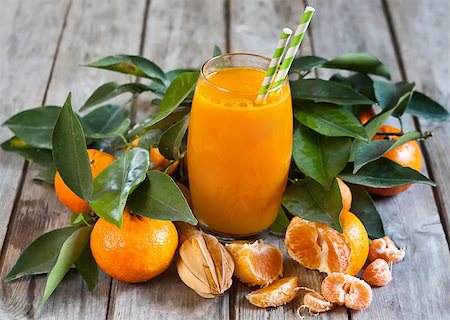 simsearch:400-07613620,k - Glass of fresh tangerine juice with ripe tangerines, leaves and old-fashioned straws. Stockbilder - Microstock & Abonnement, Bildnummer: 400-08112751