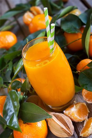 simsearch:400-07613620,k - Glass of fresh tangerine juice with ripe tangerines, leaves and old-fashioned straws. Stockbilder - Microstock & Abonnement, Bildnummer: 400-08112752