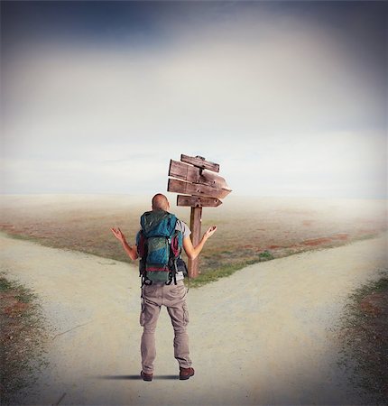 Uncertain explorer is lost at a crossroads Stock Photo - Budget Royalty-Free & Subscription, Code: 400-08112767