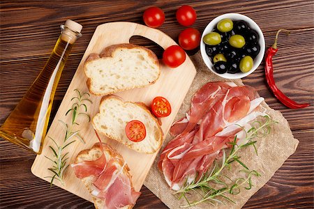 simsearch:400-08291219,k - Bruschetta ingredients - prosciutto, olives, tomatoes. Top view on wooden table Stock Photo - Budget Royalty-Free & Subscription, Code: 400-08112918