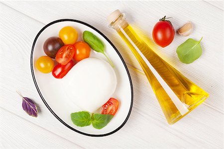simsearch:400-08071423,k - Mozzarella, tomatoes, basil and olive oil on wooden table Foto de stock - Royalty-Free Super Valor e Assinatura, Número: 400-08113651