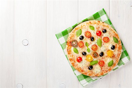 simsearch:400-08960199,k - Italian pizza with cheese, tomatoes, olives and basil on wooden table. Top view with copy space Stock Photo - Budget Royalty-Free & Subscription, Code: 400-08113664