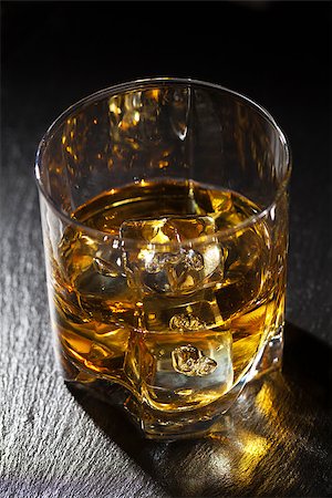 dark rum - Glass of whiskey with ice on black stone table Stock Photo - Budget Royalty-Free & Subscription, Code: 400-08113714