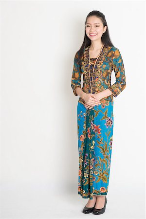 Full length Southeast Asian female in batik dress standing on plain background. Stock Photo - Budget Royalty-Free & Subscription, Code: 400-08113763