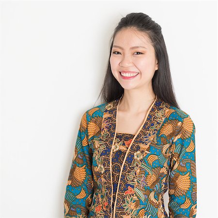 Portrait of Southeast Asian woman in batik dress on plain background. Stock Photo - Budget Royalty-Free & Subscription, Code: 400-08113805