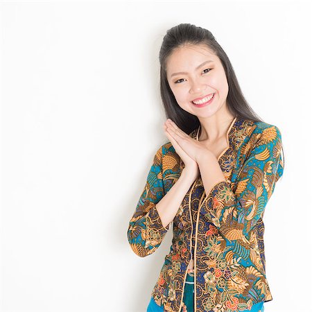 Portrait of happy Southeast Asian woman in batik dress on plain background. Stock Photo - Budget Royalty-Free & Subscription, Code: 400-08113806