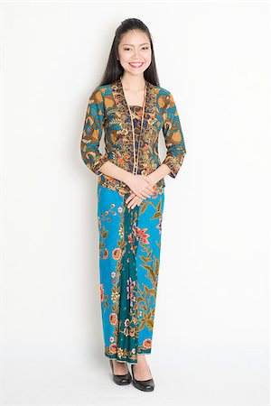 Full length Southeast Asian girl in batik dress standing on plain background. Stock Photo - Budget Royalty-Free & Subscription, Code: 400-08113802
