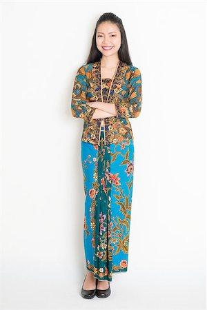 Full body Southeast Asian girl in batik dress standing on plain background. Stock Photo - Budget Royalty-Free & Subscription, Code: 400-08113803