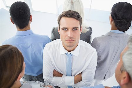 sad indian woman images - Unhappy businessman looking at camera with his colleague around him in office Stock Photo - Budget Royalty-Free & Subscription, Code: 400-08135945