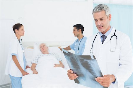 Male and female doctors examining x-ray with patient Stock Photo - Budget Royalty-Free & Subscription, Code: 400-08136159