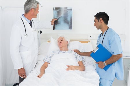 Male doctors examining x-ray with patient at the hospital Stock Photo - Budget Royalty-Free & Subscription, Code: 400-08136162