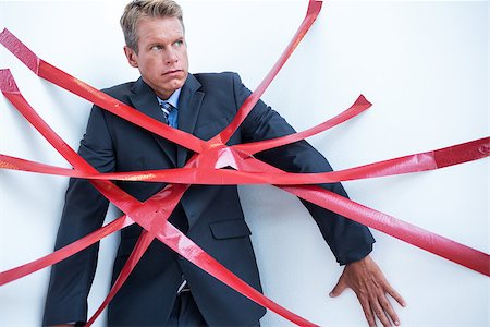 Businessman trapped by red tape on white background Stock Photo - Budget Royalty-Free & Subscription, Code: 400-08136266