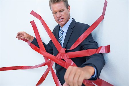 Businessman trapped by red tape on white background Stock Photo - Budget Royalty-Free & Subscription, Code: 400-08136269