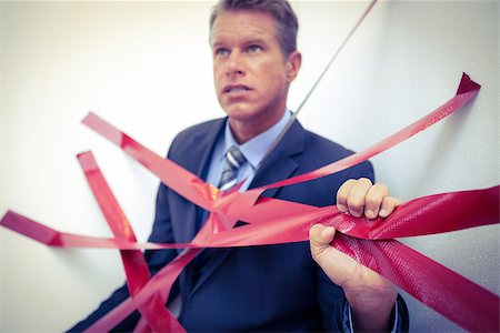 Businessman trapped by red tape on white background Stock Photo - Budget Royalty-Free & Subscription, Code: 400-08136277