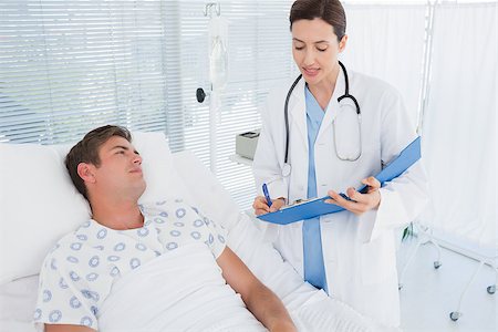simsearch:400-06734647,k - Doctor taking care of patient in hospital room Stock Photo - Budget Royalty-Free & Subscription, Code: 400-08136692