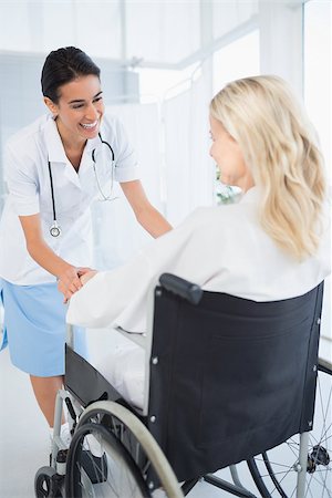 simsearch:6109-06195982,k - Happy doctor smiling at her patient in wheelchair in hospital Fotografie stock - Microstock e Abbonamento, Codice: 400-08136727