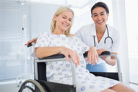simsearch:6109-06195982,k - Doctor and patient in wheelchair smiling at camera in hospital Fotografie stock - Microstock e Abbonamento, Codice: 400-08136721