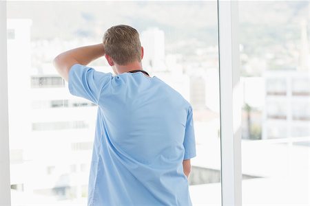 simsearch:400-07334526,k - Male doctor looking through windows in hospital Stock Photo - Budget Royalty-Free & Subscription, Code: 400-08136759