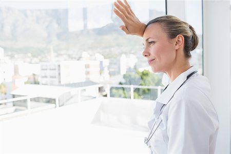 simsearch:400-07334526,k - Confident female doctor looking through windows in hospital Stockbilder - Microstock & Abonnement, Bildnummer: 400-08136752