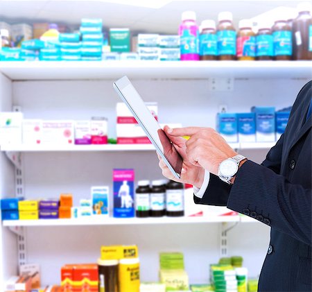 Businessman in suit using digital tablet against close up of shelves of drugs Stock Photo - Budget Royalty-Free & Subscription, Code: 400-08137546