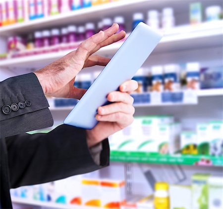 Businessman scrolling on his digital tablet against close up of shelves of drugs Stock Photo - Budget Royalty-Free & Subscription, Code: 400-08137547