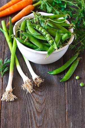 simsearch:400-05294178,k - Fresh green peas in a white bowl and vegetables on wooden kitchen table. Stockbilder - Microstock & Abonnement, Bildnummer: 400-08138380