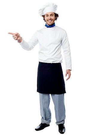 Smiling cook in uniform pointing to his right Stock Photo - Budget Royalty-Free & Subscription, Code: 400-08130664