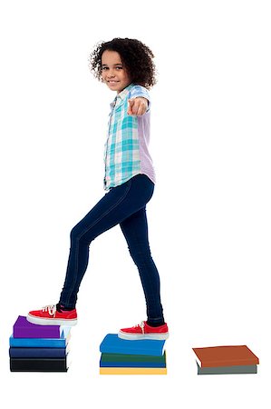 School girl standing on books, pointing finger. Photographie de stock - Aubaine LD & Abonnement, Code: 400-08130854