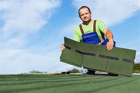 simsearch:400-05674138,k - Man installing bitumen roof shingles - holding a few pieces Foto de stock - Super Valor sin royalties y Suscripción, Código: 400-08131538