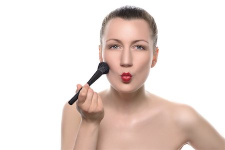pursed - Close up Bare Young Pretty Woman Putting Makeup on Face Using Brush with Pouting Lips and Looking at the Camera. Isolated on White Background. Stock Photo - Budget Royalty-Free & Subscription, Code: 400-08157565