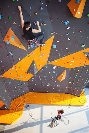 Young man practicing rock-climbing on a rock wall indoors Stock Photo - Budget Royalty-Free & Subscription, Code: 400-08151311