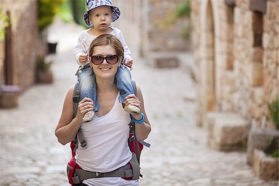 Young Caucasian woman tourist carrying her little son on shoulders Stock Photo - Royalty-Free, Artist: photobac, Image code: 400-08151335