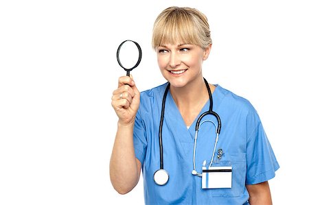 Pretty physician looking through magnifying glass, observing something closely. Stock Photo - Budget Royalty-Free & Subscription, Code: 400-08151523
