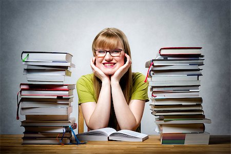 school girl holding pile of books - young happy female student with glasses and lots of books at a table Stock Photo - Budget Royalty-Free & Subscription, Code: 400-08152517