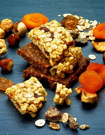 Stack of Useful Granola Bars with Muesli, Nuts, Seed, Raisins and Dried Apricots closeup on Black Stone background Stock Photo - Budget Royalty-Free & Subscription, Code: 400-08152551