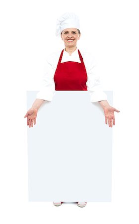 Female cook showing white blank ad board, full length shot Stock Photo - Budget Royalty-Free & Subscription, Code: 400-08153113