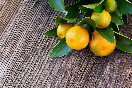 Tangerine tree branch  on wooden table background Stock Photo - Budget Royalty-Free & Subscription, Code: 400-08153539
