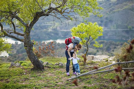 Young woman supporting son while he is making first steps outdoors Stock Photo - Budget Royalty-Free & Subscription, Code: 400-08153638