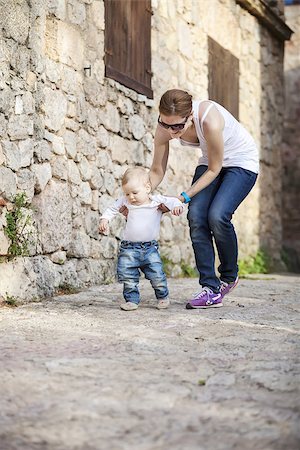 Cute baby boy makes his first steps with help of his mother Stock Photo - Budget Royalty-Free & Subscription, Code: 400-08153657