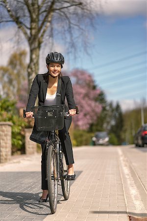 Happy Young Businesswoman Biking at the Street with Head Gear Going to her Office, Looking at the Camera Stock Photo - Budget Royalty-Free & Subscription, Code: 400-08153675