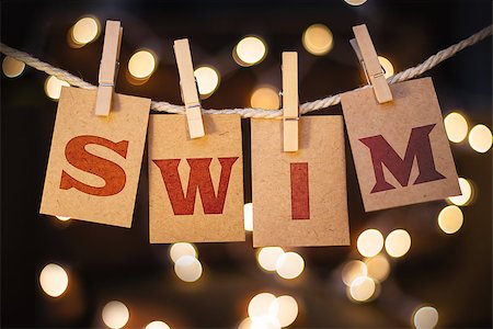 simsearch:400-08153760,k - The word SWIM printed on clothespin clipped cards in front of defocused glowing lights. Stockbilder - Microstock & Abonnement, Bildnummer: 400-08153848