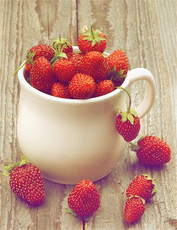 simsearch:400-08020671,k - White Tea Cup Full of Fresh Ripe Forest Strawberries closeup on Rustic Wooden background. Retro Styled Stock Photo - Budget Royalty-Free & Subscription, Code: 400-08160105