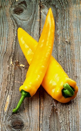 poivre de cayenne - Arrangement of Perfect Ripe Yellow Ramiro Peppers with Green Tails isolated on Rustic Wooden background Photographie de stock - Aubaine LD & Abonnement, Code: 400-08161376