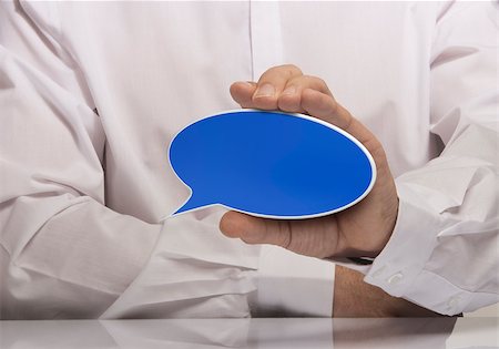 Image of a man hand holding empty blue speech balloon, white shirt and reflexion. Stock Photo - Budget Royalty-Free & Subscription, Code: 400-08184932